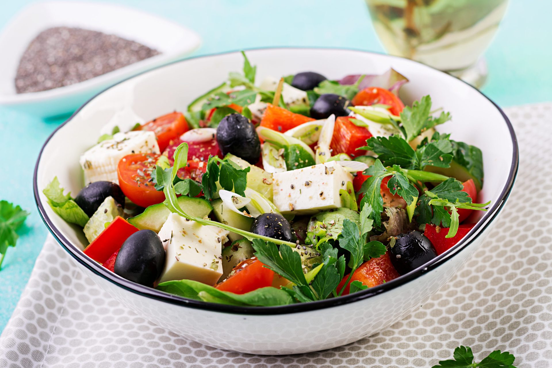 greek salad Greek salad with cucumber, tomato, sweet pepper, lettuce, green onion, feta cheese and olives with olive oil. Healthy food.